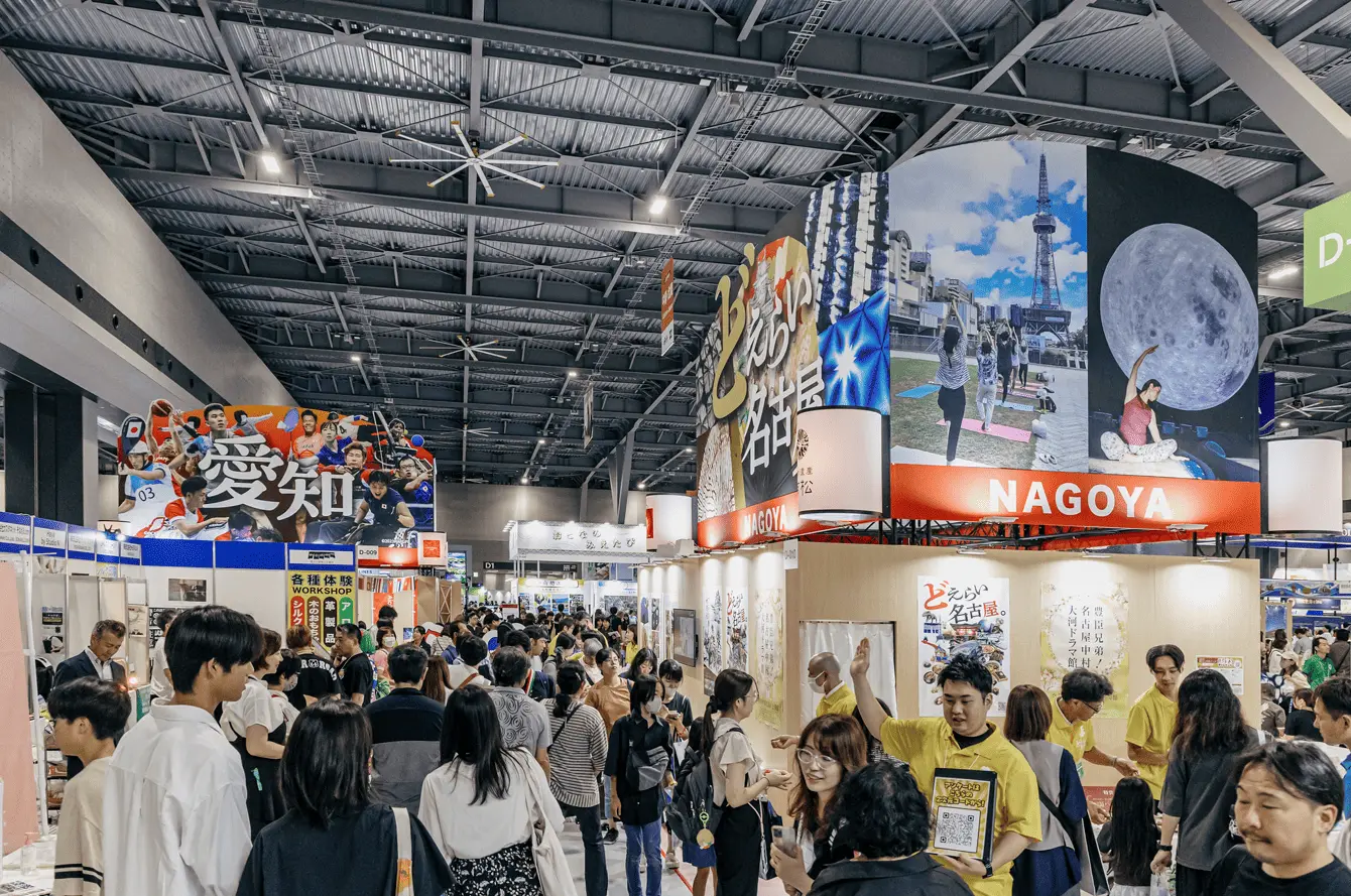Un salon animé rassemble de nombreux visiteurs autour de stands colorés et immersifs, mettant en valeur des destinations et expériences culturelles, dans une atmosphère dynamique propice aux échanges et à la découverte.